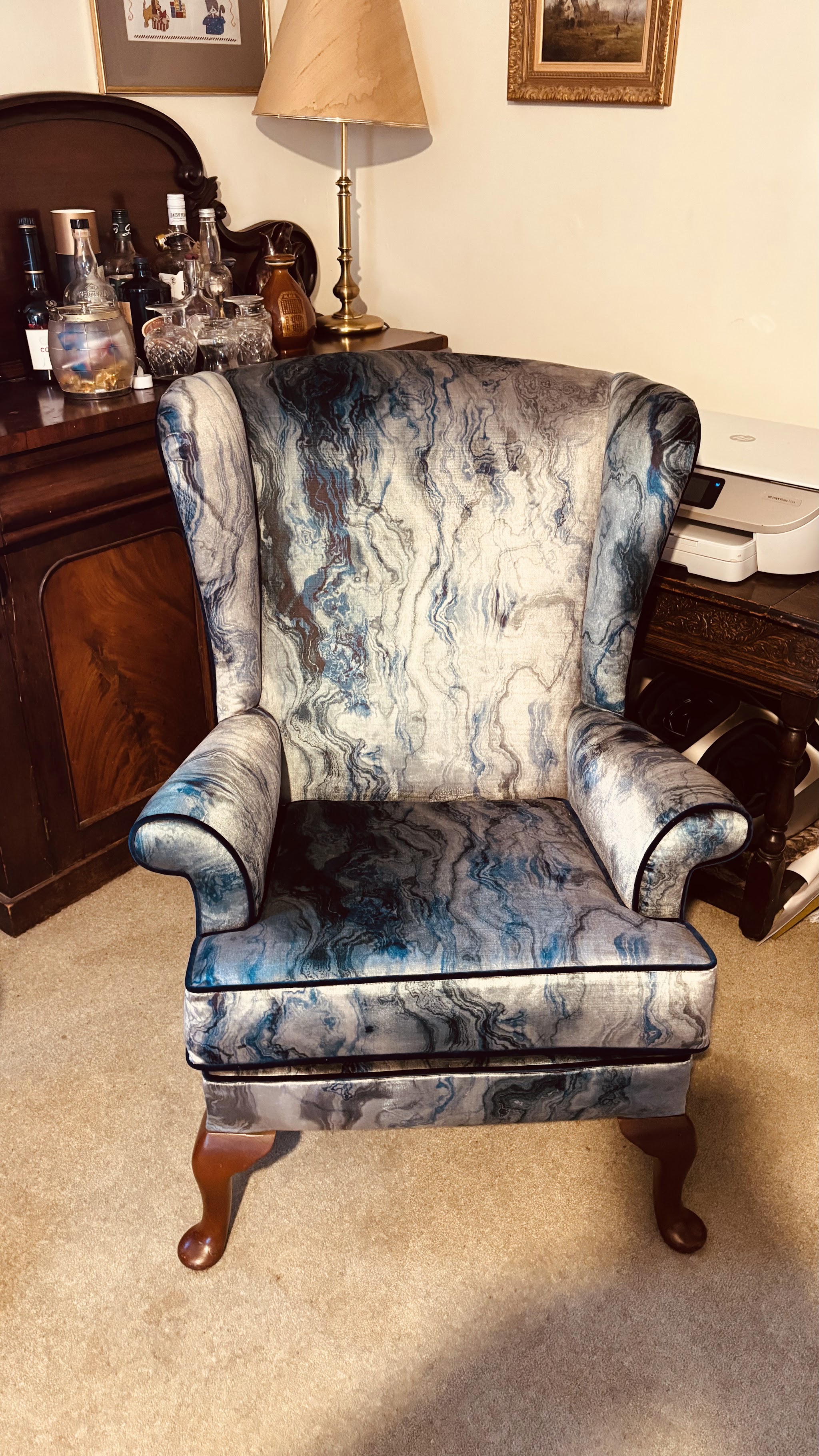 Wing chair re-upholstered in a blue and grey marbled velvet, in a client's room