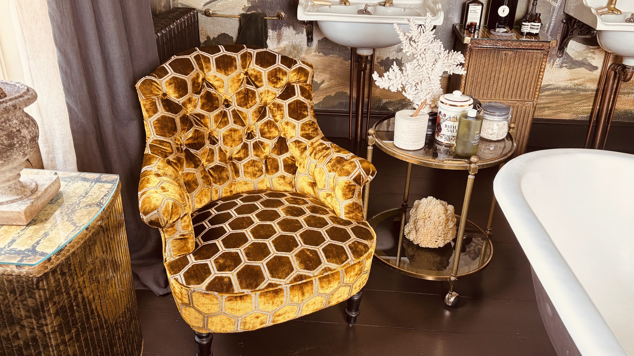 Button-back chair in mustard honeycomb velvet in a styled room beside a roll-top bath