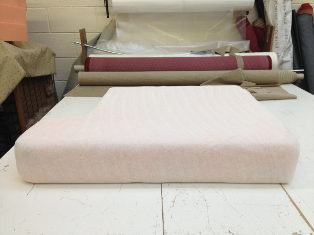 A new foam cushion interior wrapped in fibre, on the workroom bench