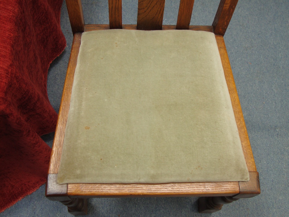 Worn green drop in seat pad sitting in a wooden dining chair