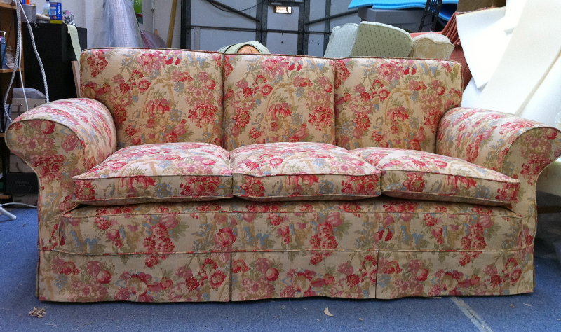 Three-seater sofa in a fixed back style loose cover in a red floral fabric