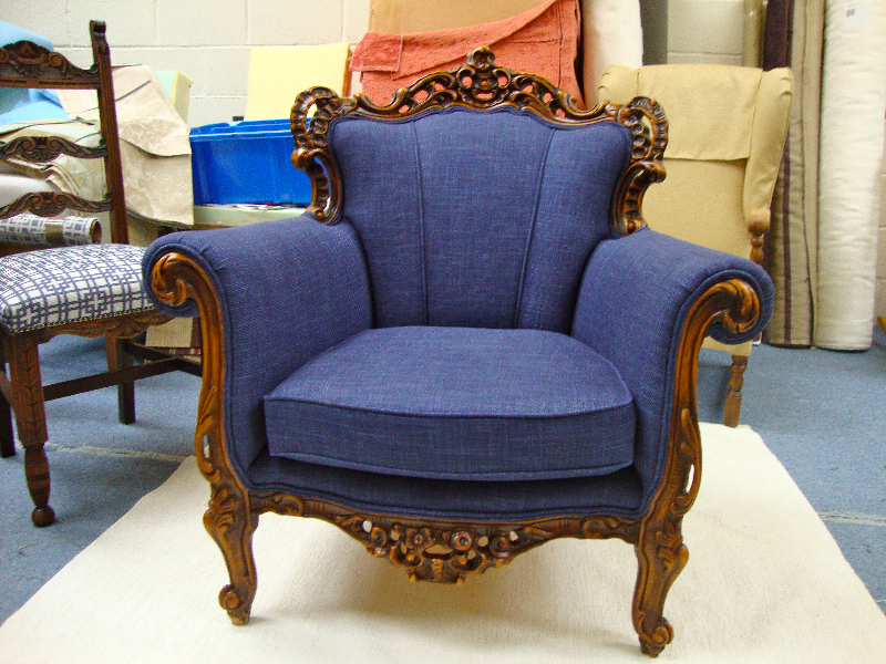 Carved show-wood armchair re-upholstered in soft blue fabric with twin piping
