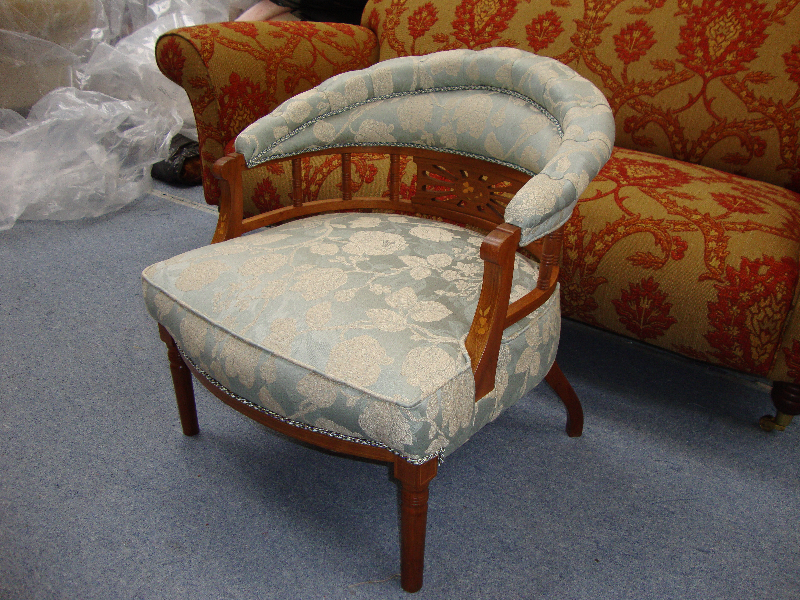 Tub chair with a carved wooden back upholstered in periwinkle damask