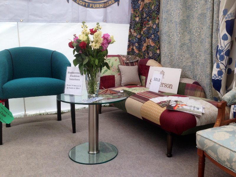 Our stand at the Royal Norfolk Show with a patchwork chaise lounge, a teal tub chair and fabric books