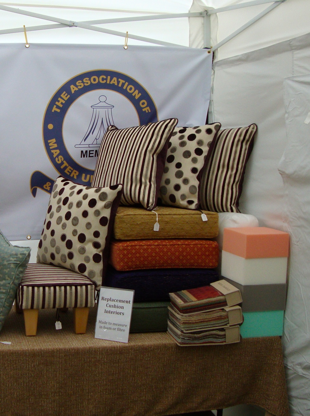 Show stand display of striped and spotted cushions, foam blocks and a small footstool
